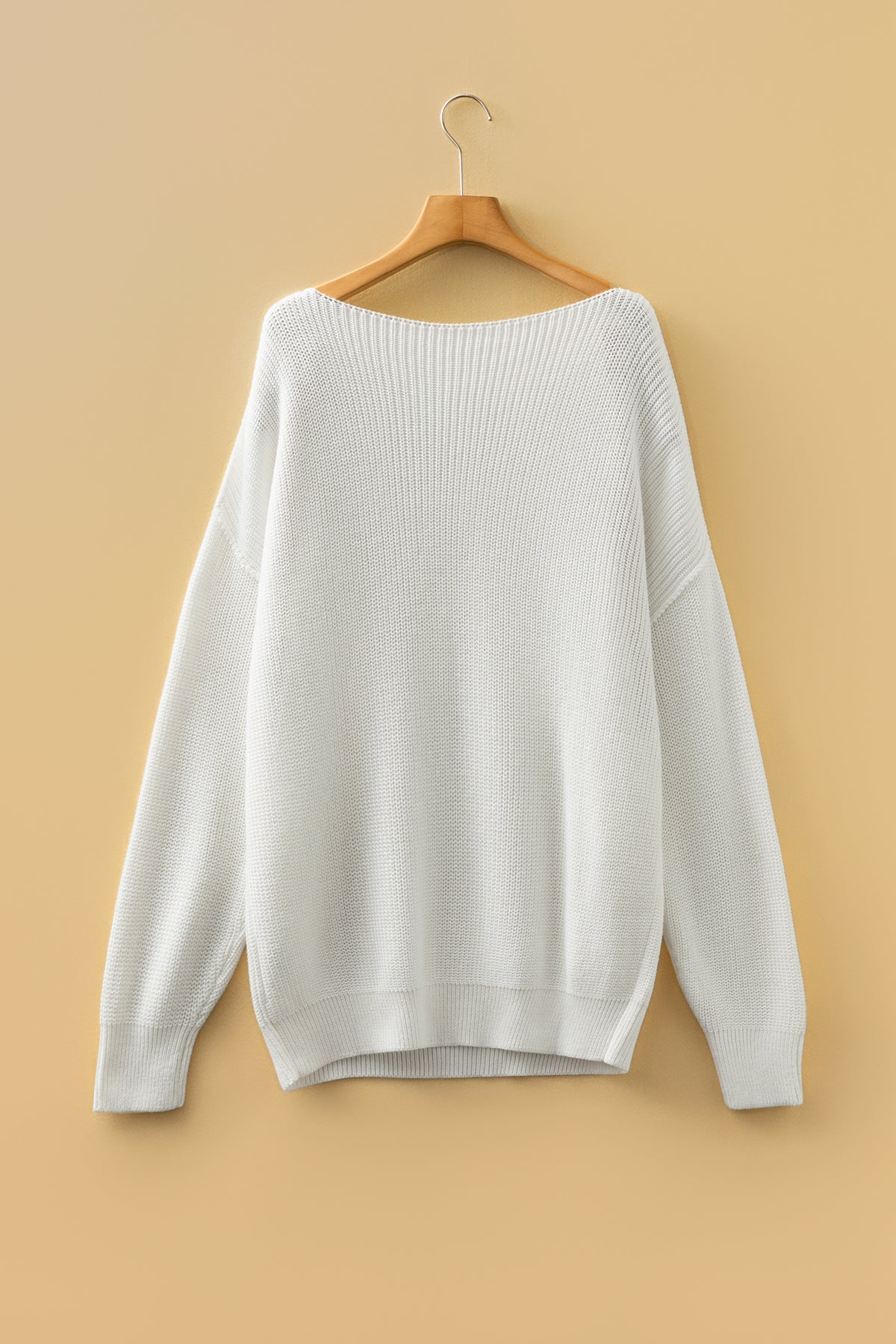 white Asymmetric Neck Drop Shoulder Baggy Sweater on a wooden hanger. Back view