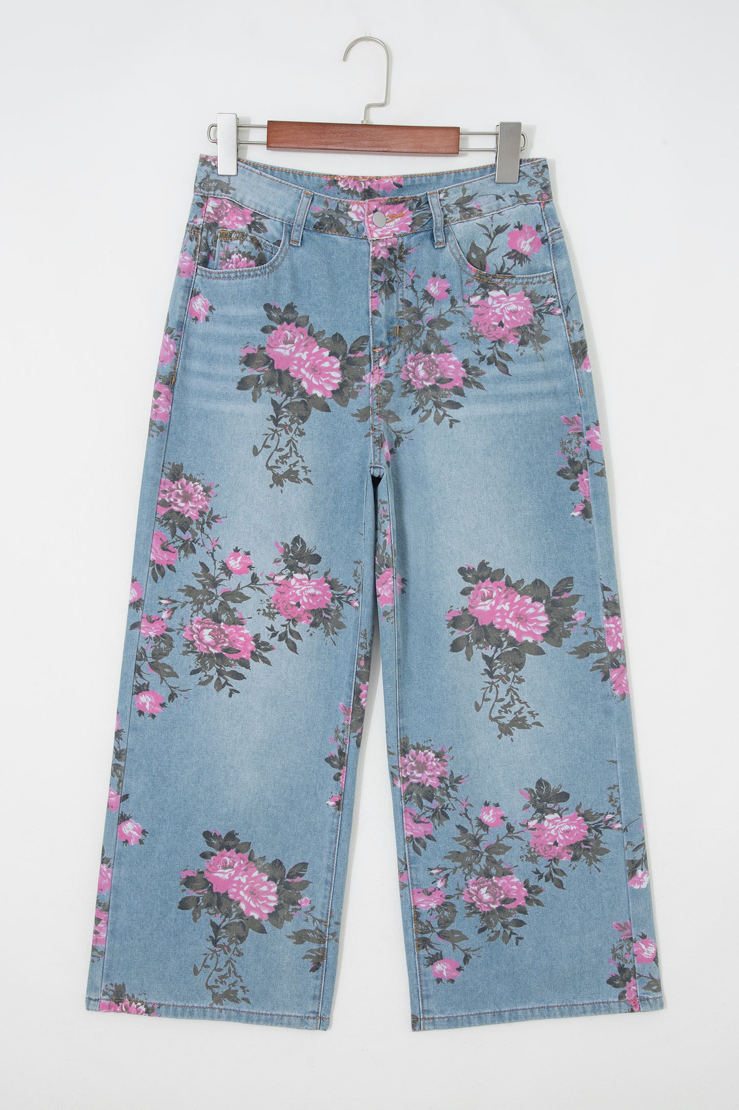 Floral-patterned jeans on a hanger against a white background front view