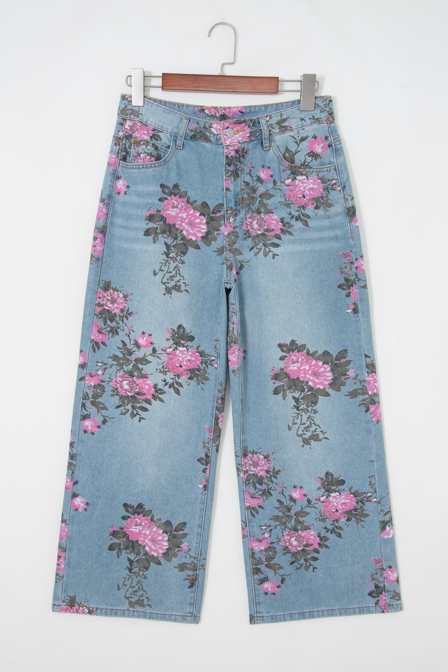 Floral-patterned jeans on a hanger against a white background front view