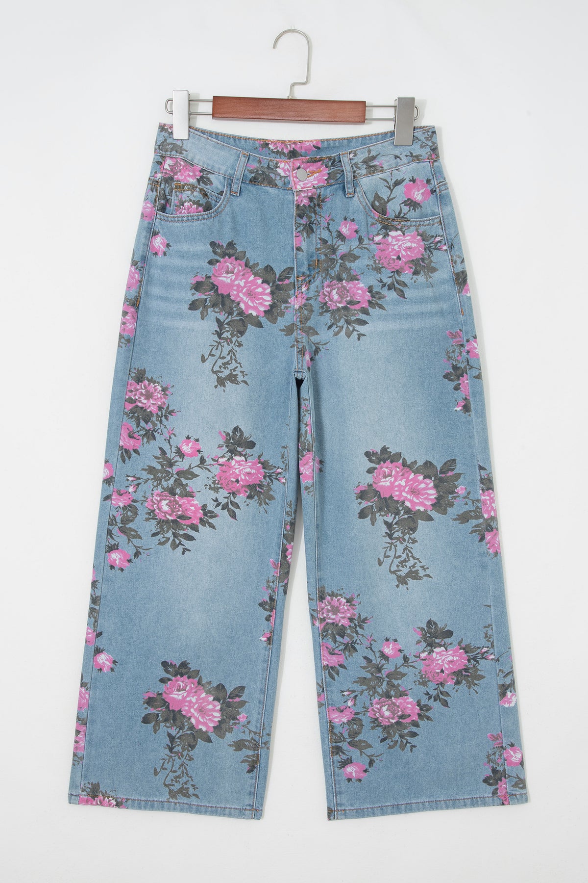 Floral-patterned jeans on a hanger against a white background front view
