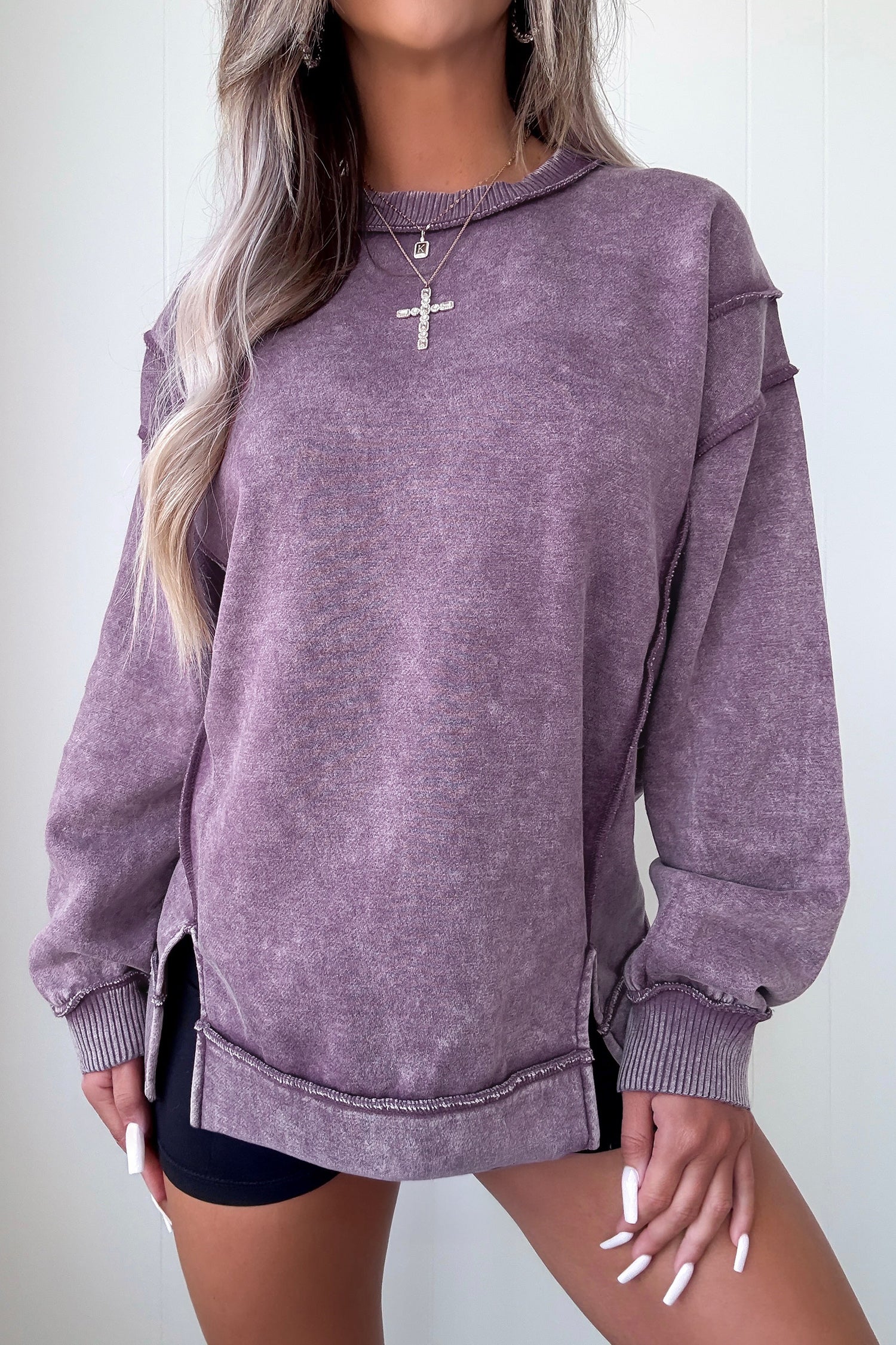 Person wearing a purple hoodie with a plain background