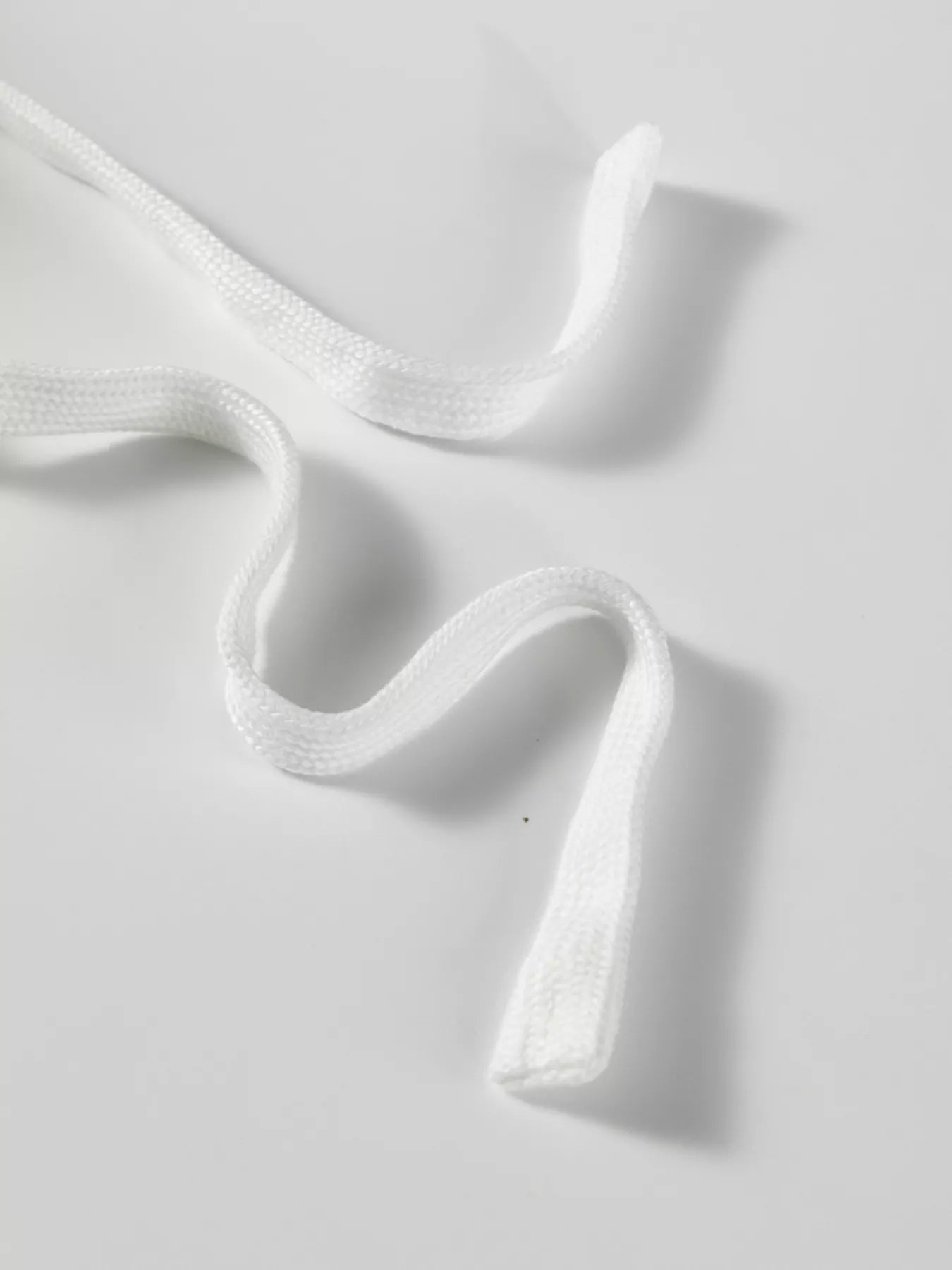 White fabric with a subtle pattern on a light gray background