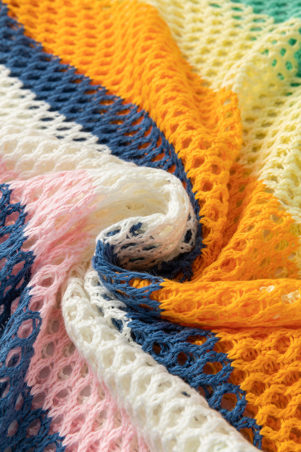 Close-up of a colorful crocheted blanket with blue, orange, and pink patterns.