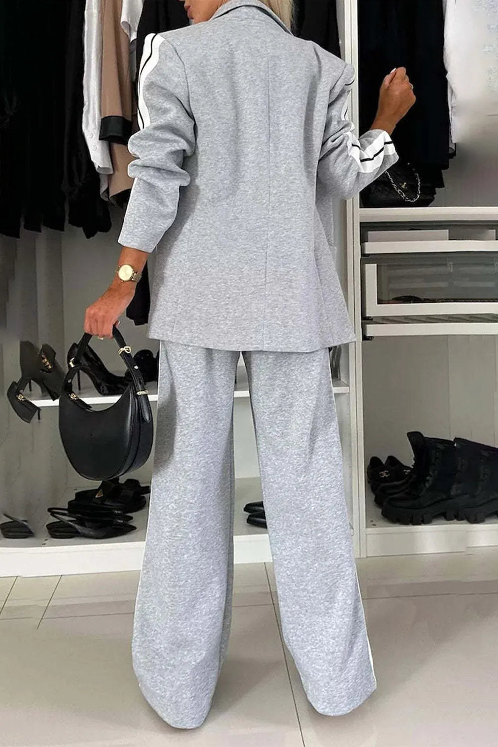 Person wearing a gray suit in a clothing store setting