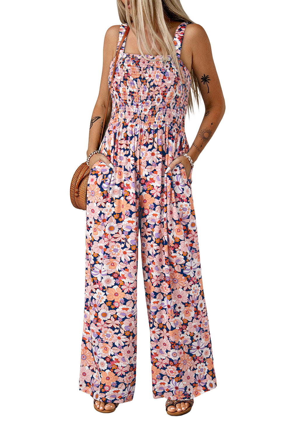 Woman wearing a floral peach  jumpsuit on a white background