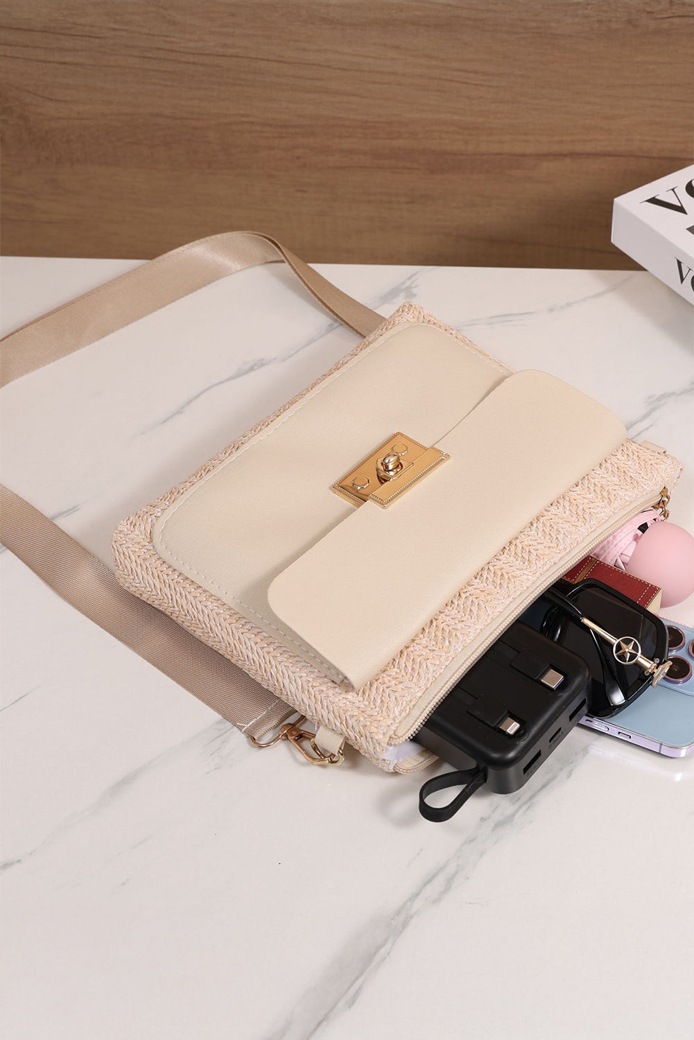 Beige handbag with a gold clasp on a white surface