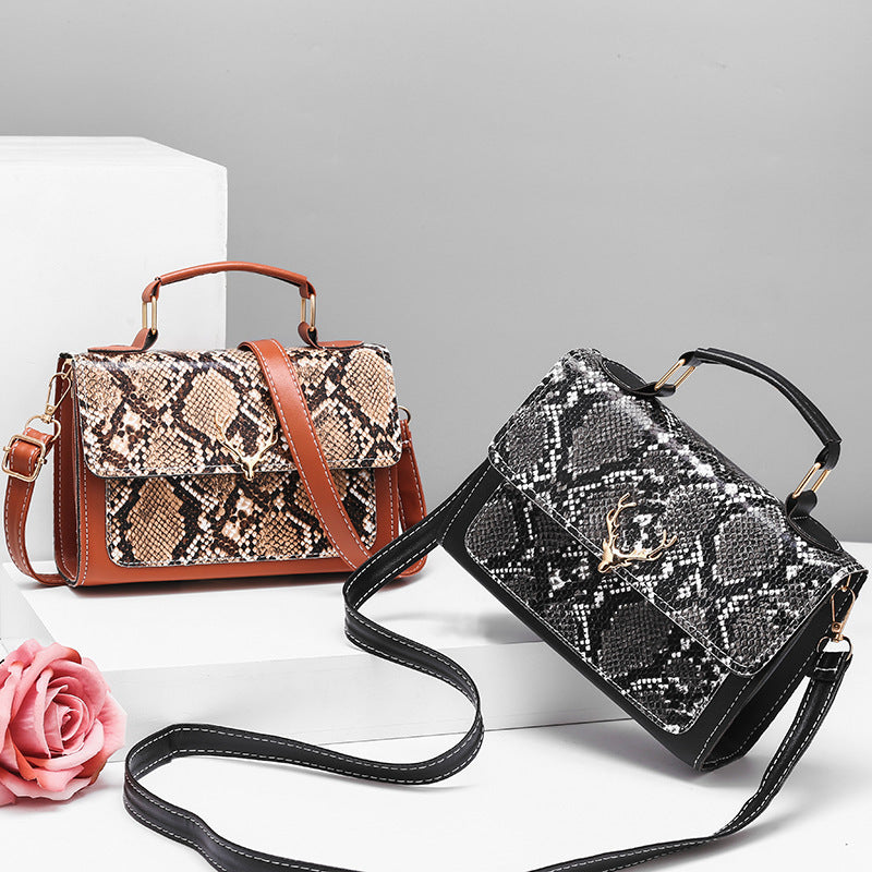 Two snakeskin-patterned handbags on a white surface with a gray background