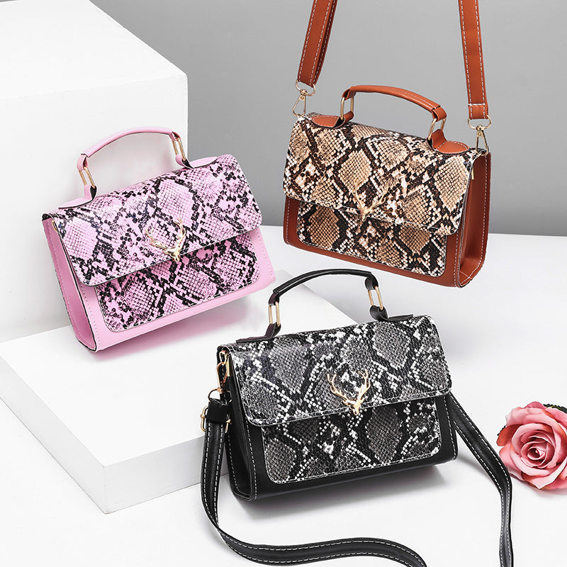 Three snakeskin-patterned handbags on a white surface with a gray background
