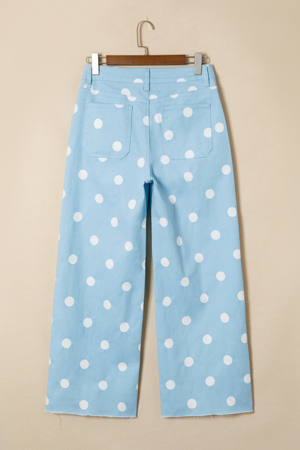 Light blue pants with white polka dots on a beige background back