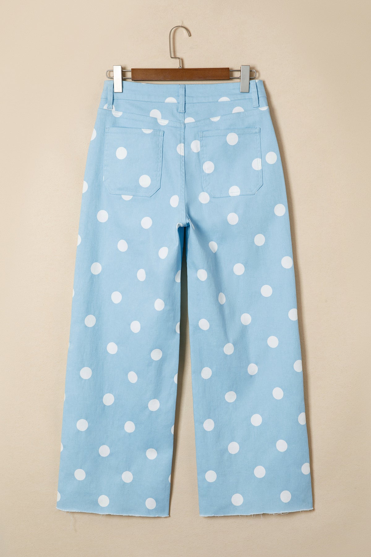 Light blue pants with white polka dots on a beige background back