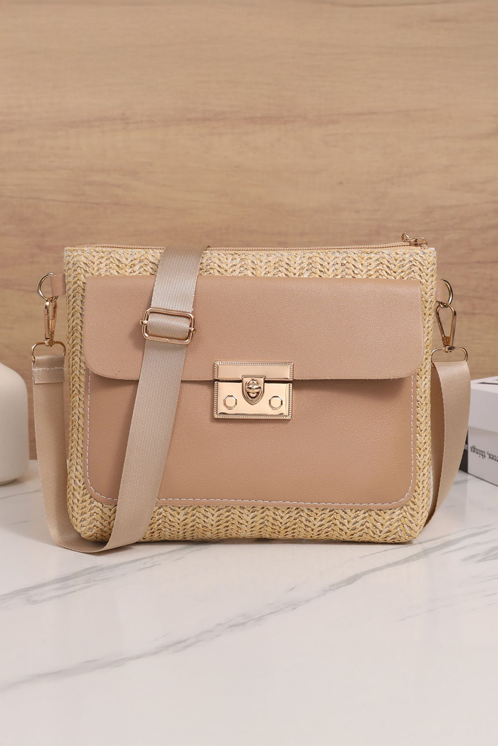 Beige handbag with straw detailing on a wooden surface