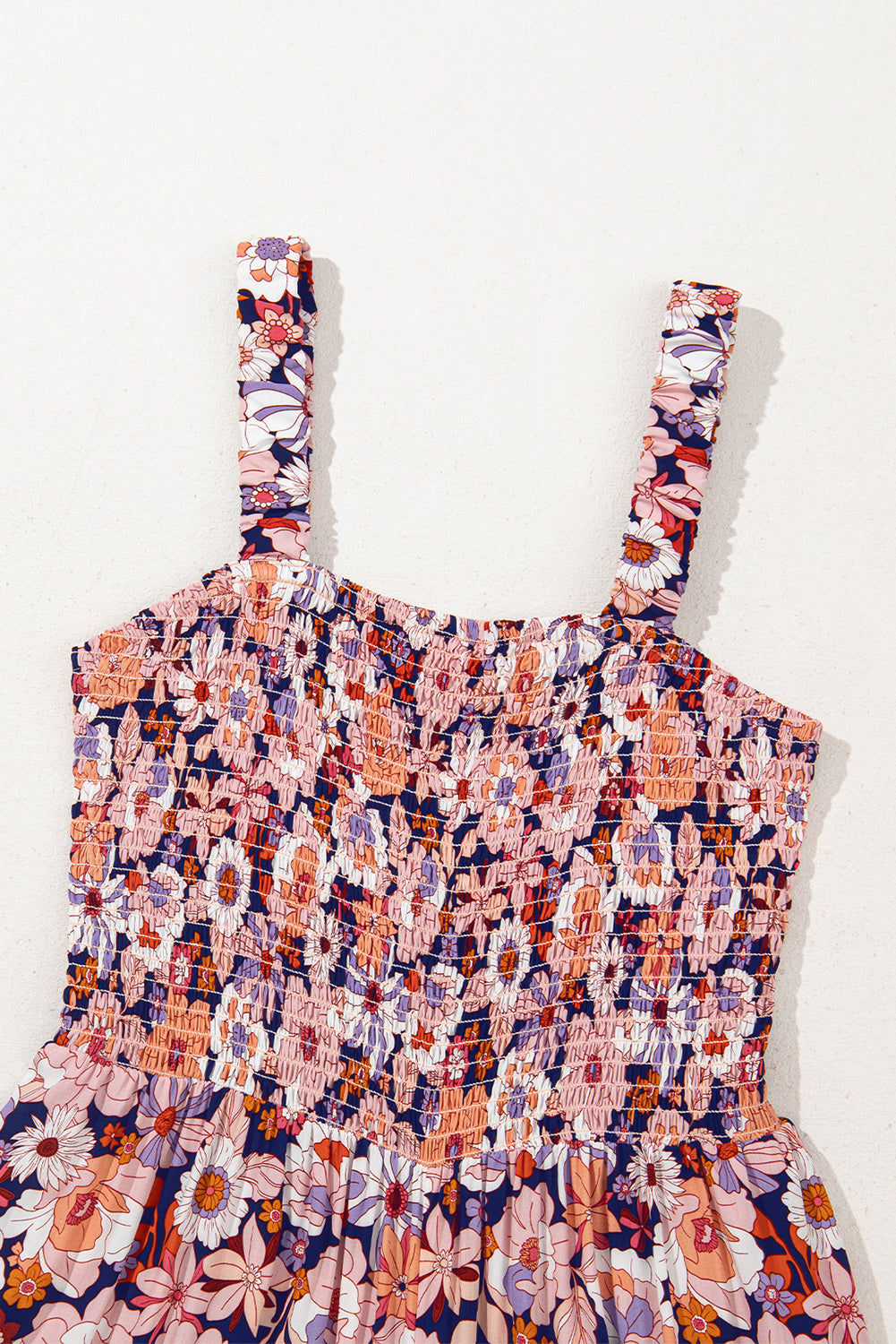 Floral peach patterned dress with thin straps on a white background