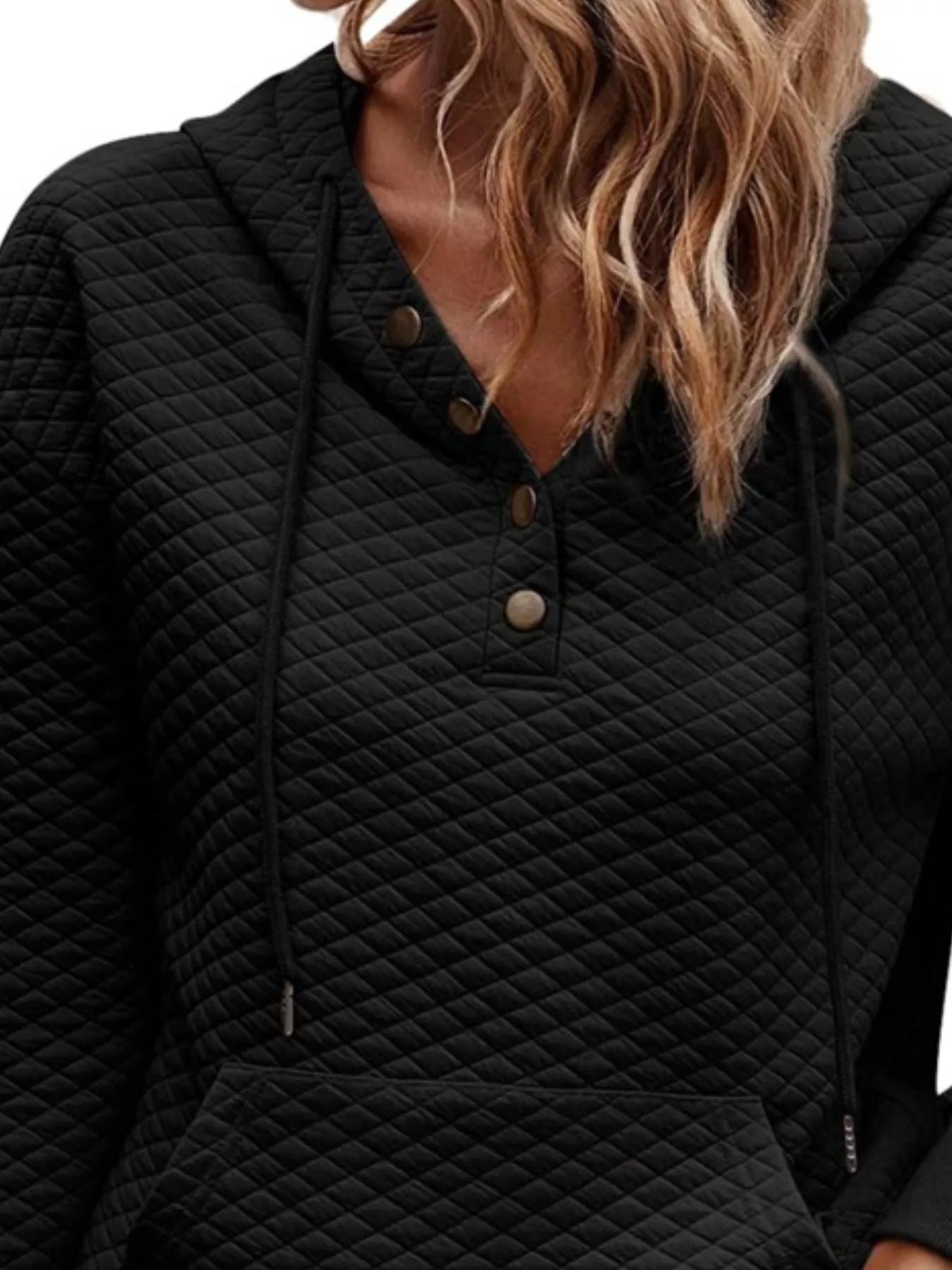 Black quilted hoodie worn by a person with blonde hair.