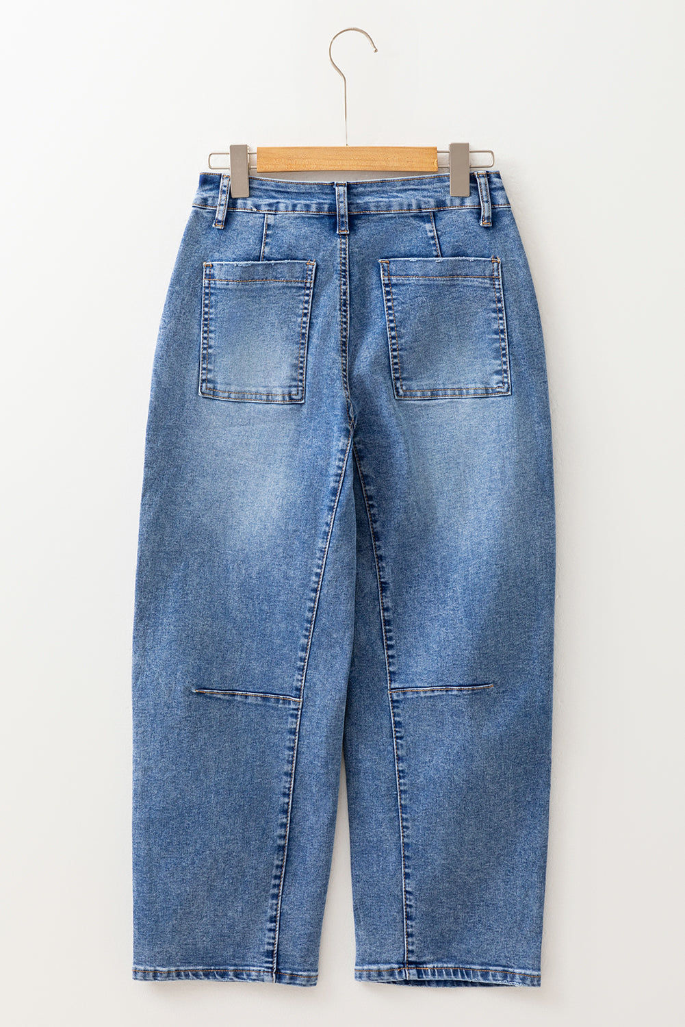 Blue jeans on a hanger against a white background