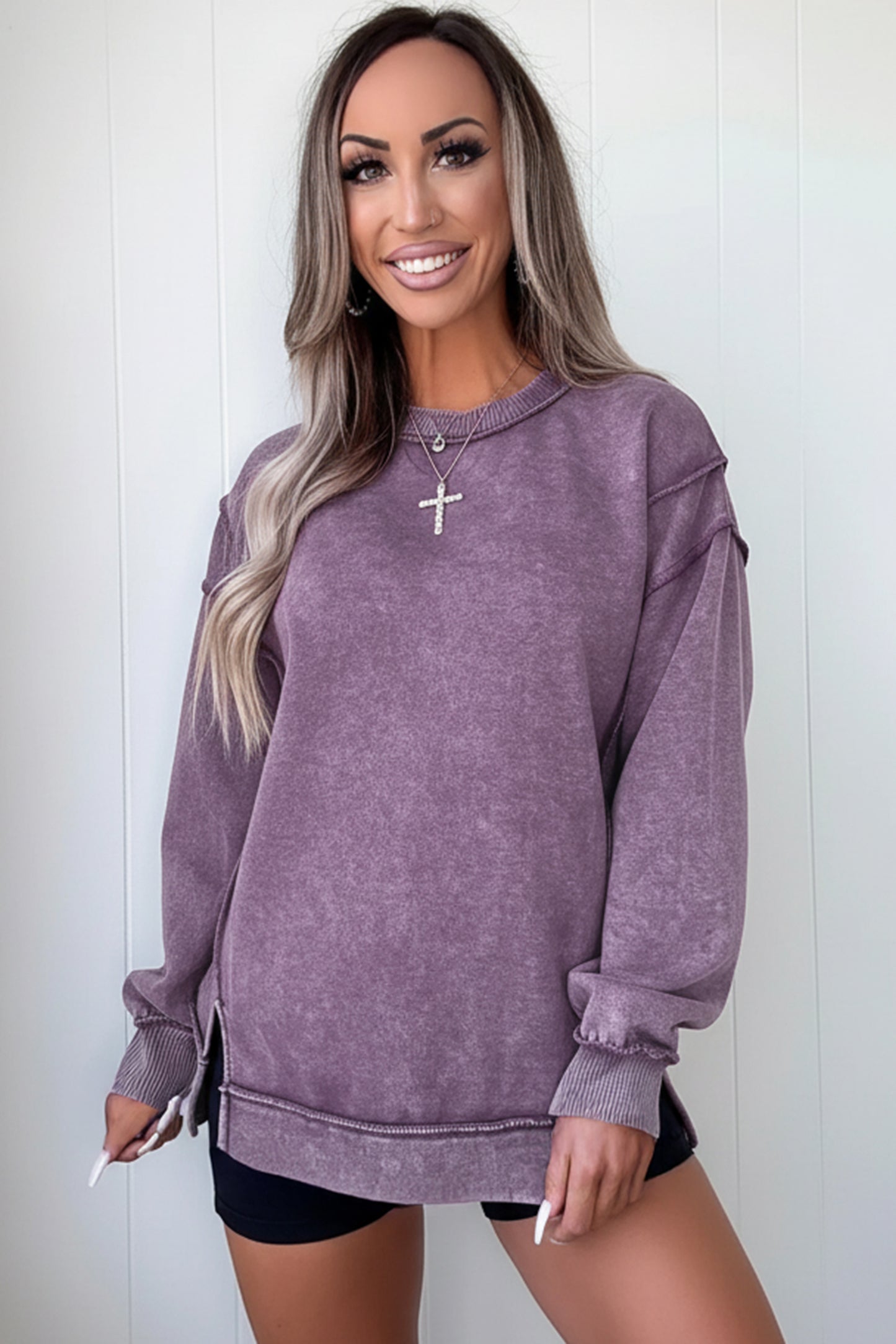 Woman wearing a purple sweatshirt against a white background