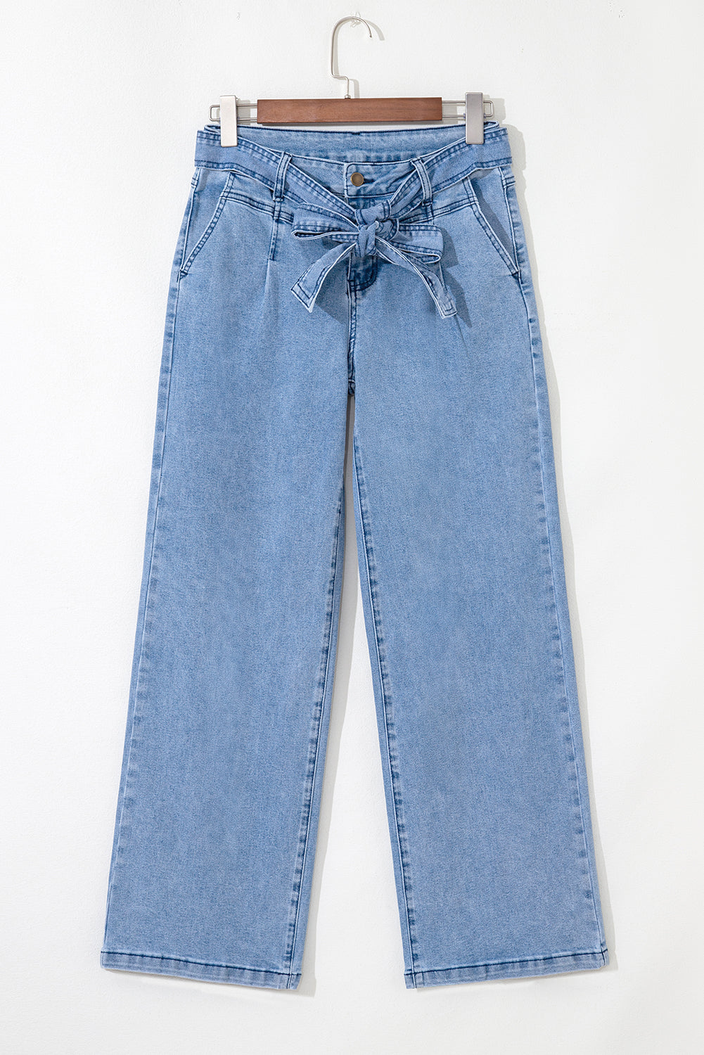 Light blue jeans with a tie-waist design on a white background