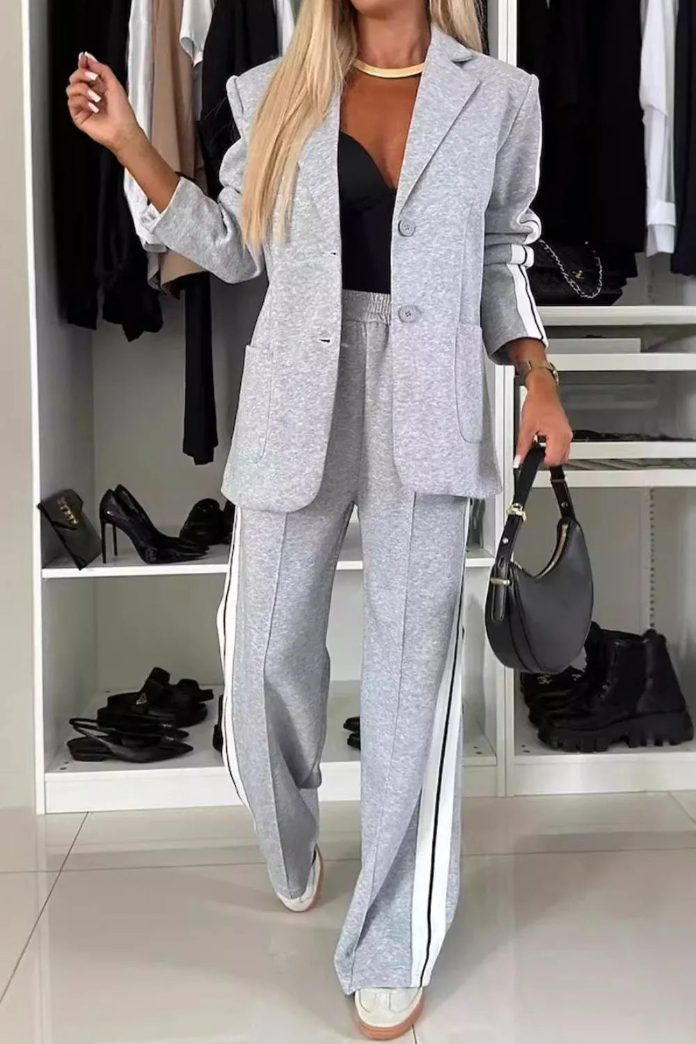 Person wearing a gray suit in a room with shelves and shoes.