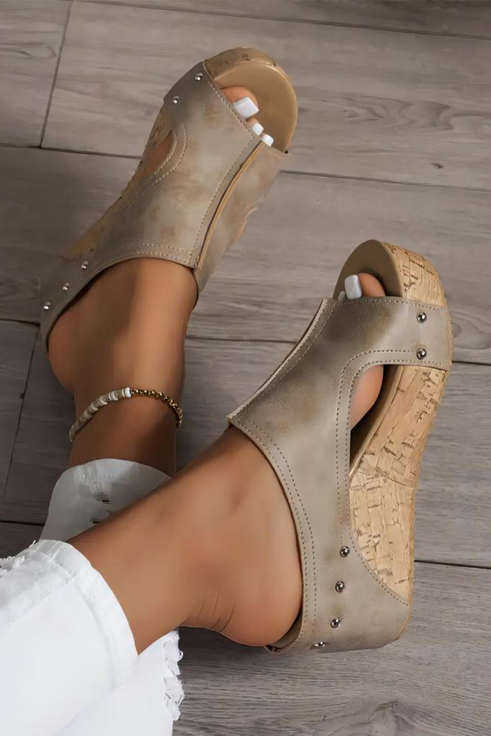 Beige wedge sandals on a wooden floor