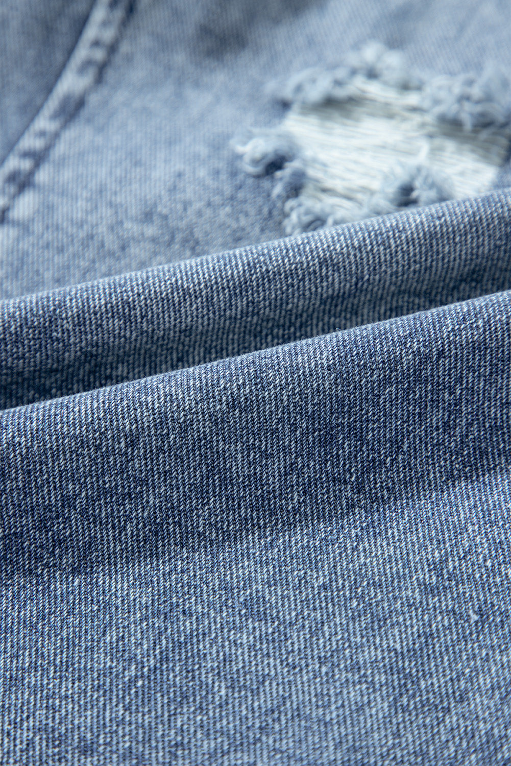 Close-up of blue denim fabric with a distressed effect