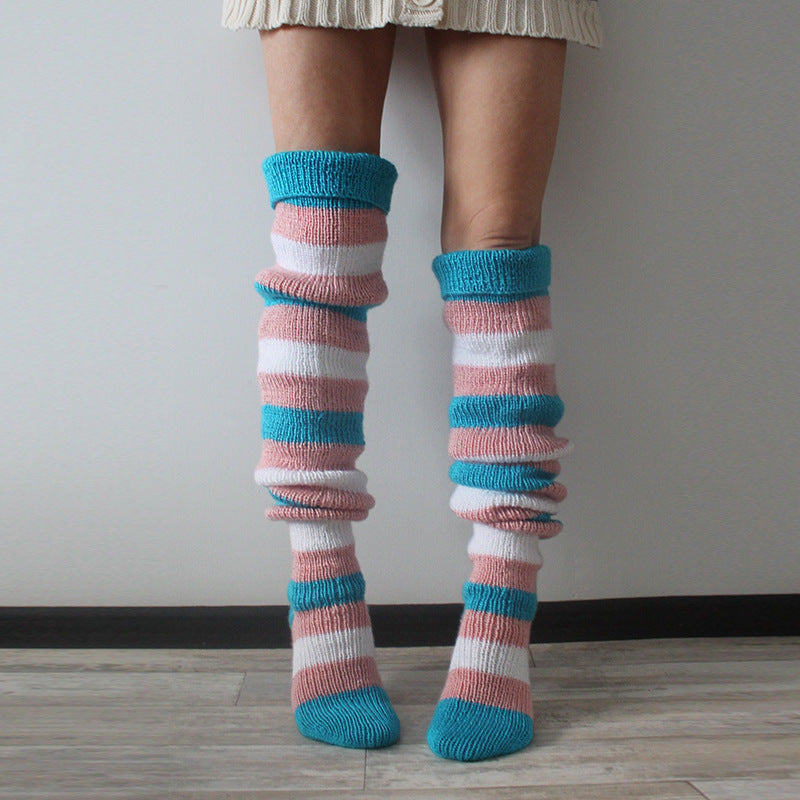 Colorful striped knee-high socks worn by a person on a plain background