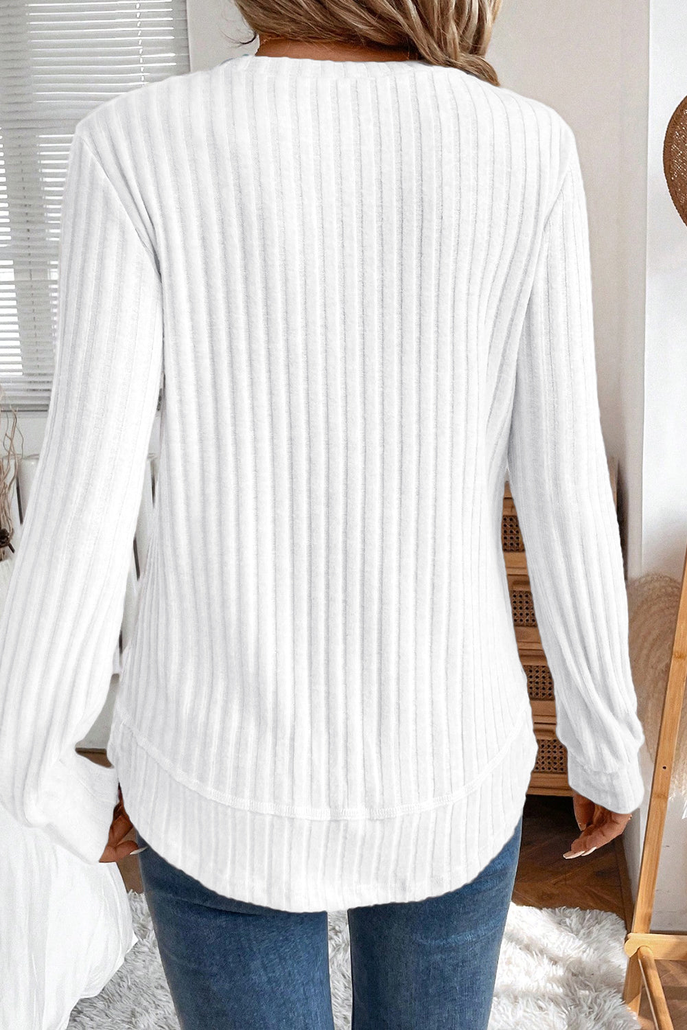 White ribbed sweater worn by a person, with a neutral background