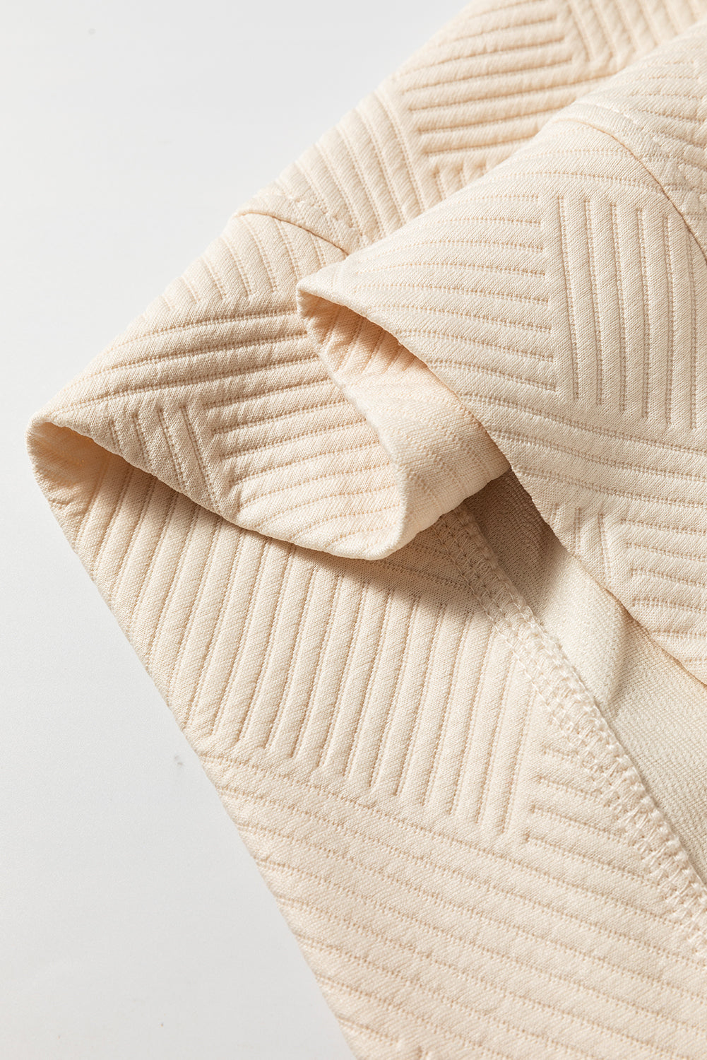 Close-up of a textured beige fabric on a light gray background