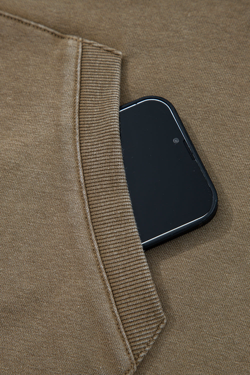 Phone in a pocket of a brown jacket