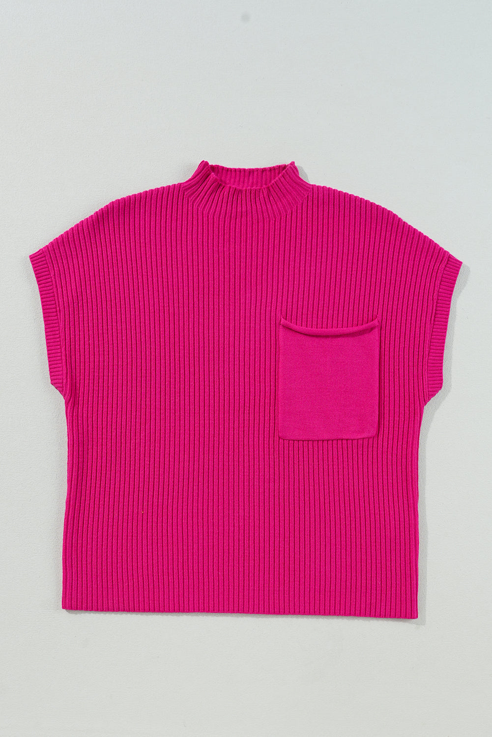 Pink sleeveless ribbed sweater with a pocket on a light gray background