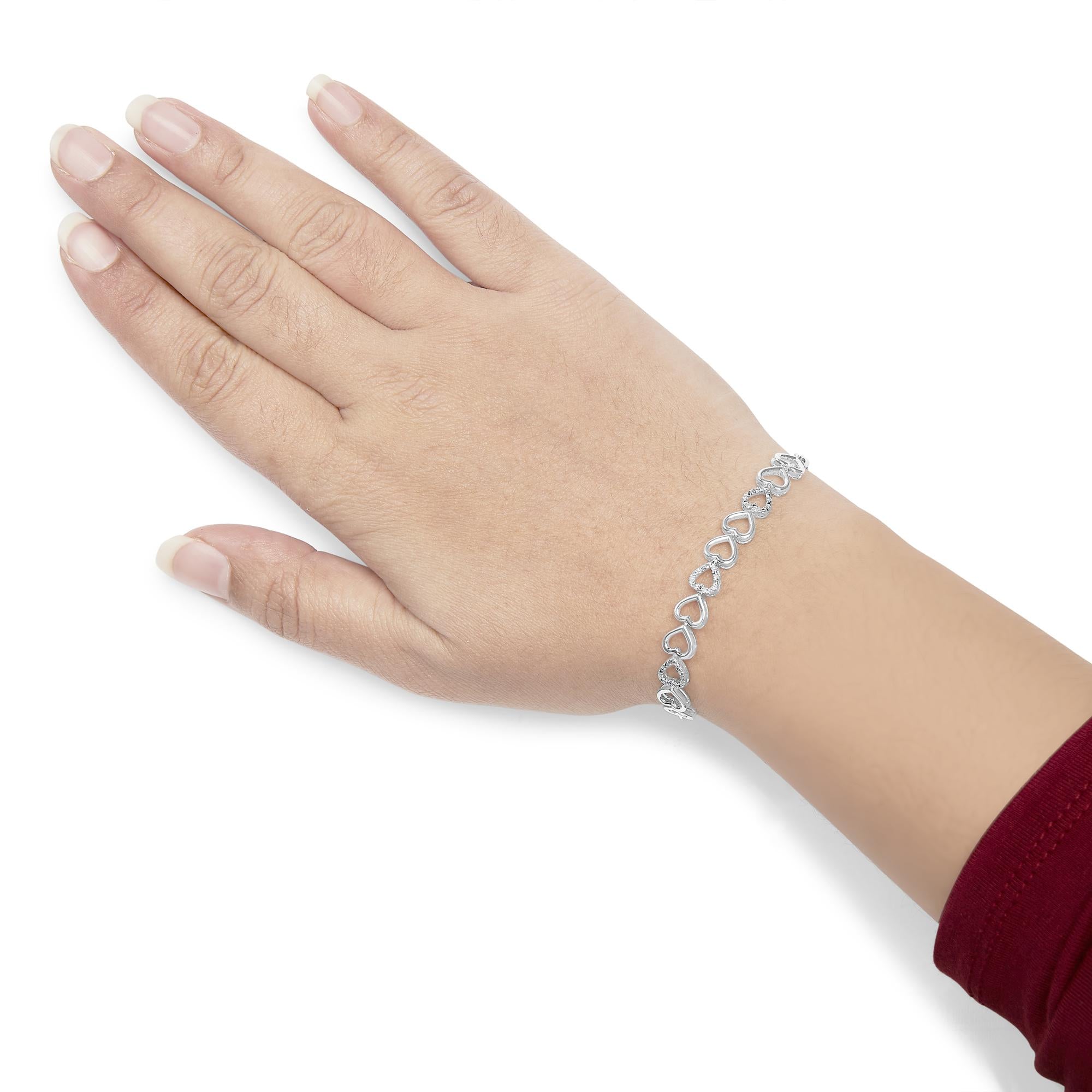 Silver bracelet on a hand against a white background