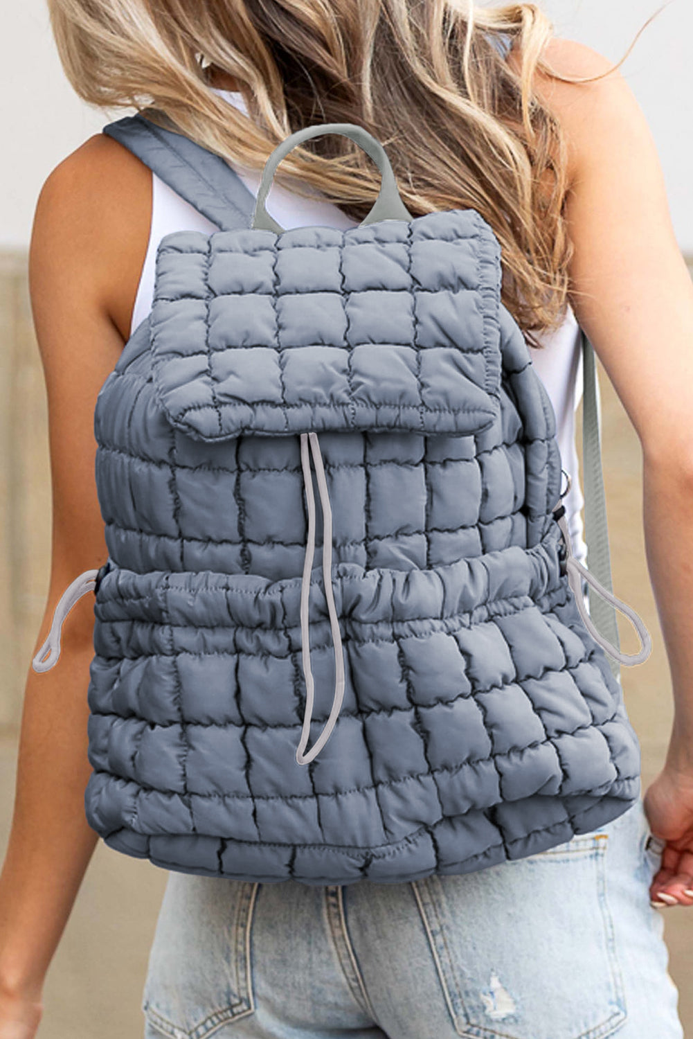 Model wearing a Chic dusk blue Quilted Puffer Flap Backpack across the back