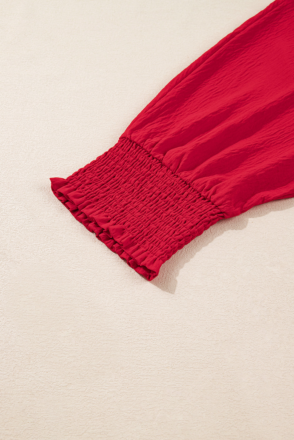 Red fabric with a textured edge on a beige background