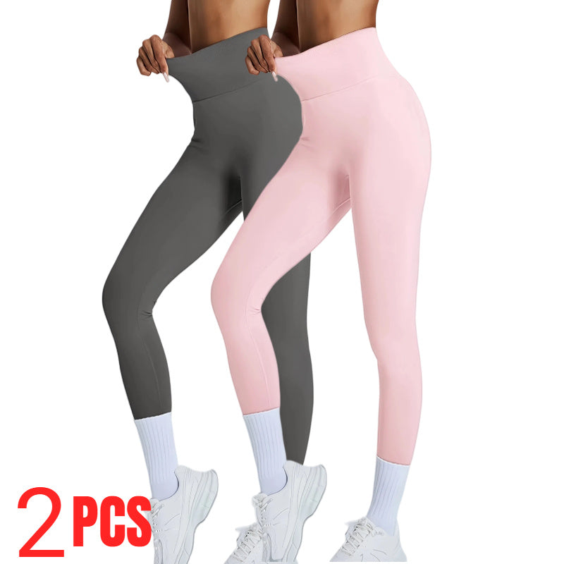 Two pairs of leggings, one gray and one pink, held by a person on a white background.
