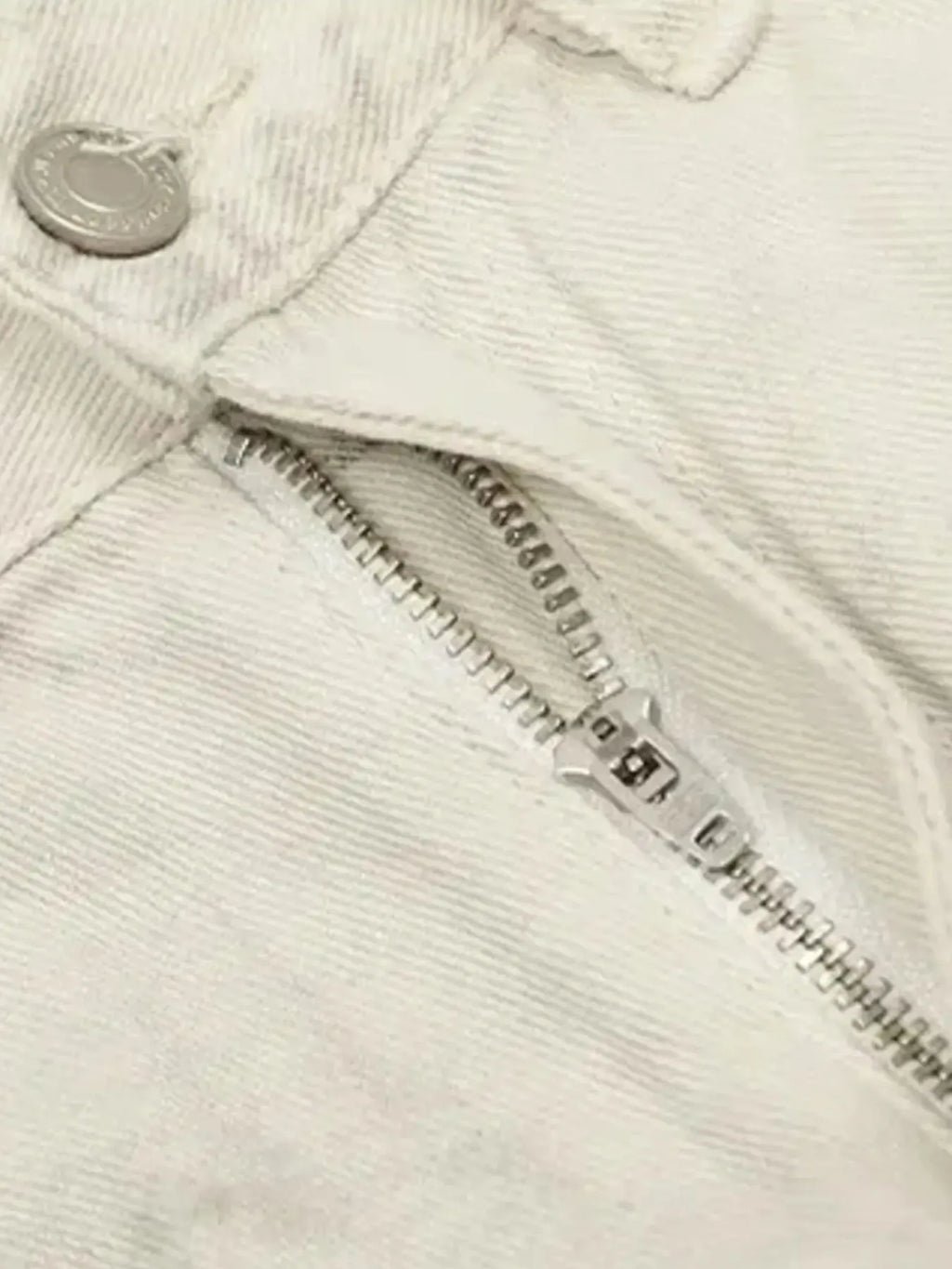 a pair of vintage washed off white jeans zipper close up