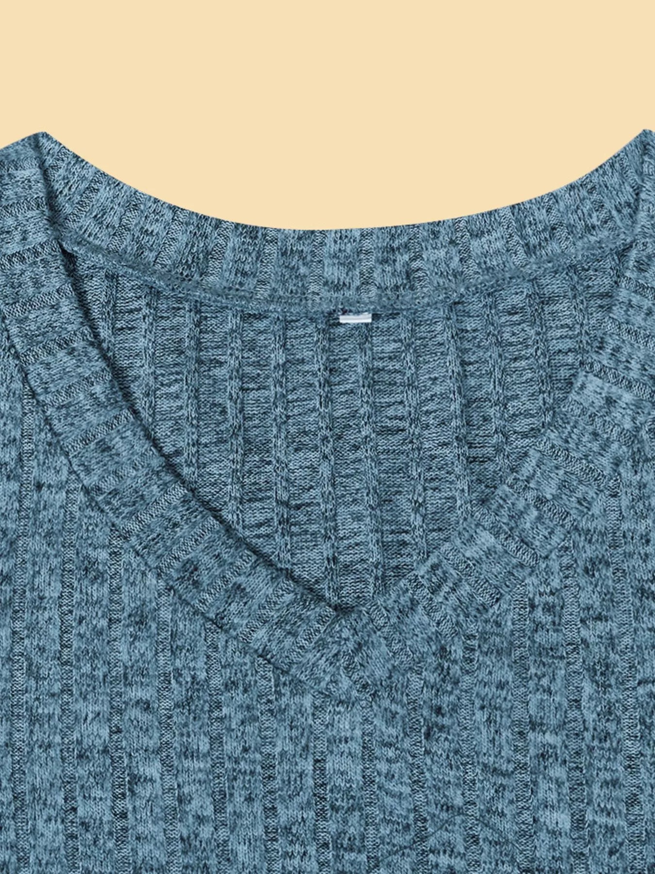 Close-up of a blue knitted sweater on a beige background