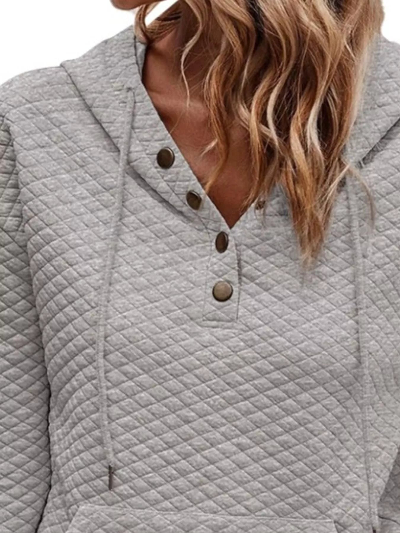 Gray quilted jacket with button details on a neutral background