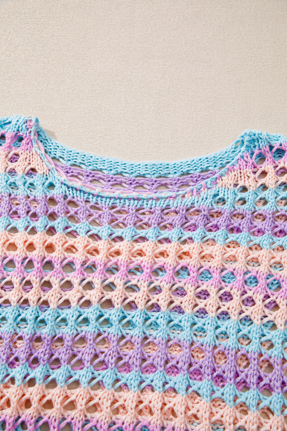 Colorful crocheted garment with a patterned texture on a neutral background