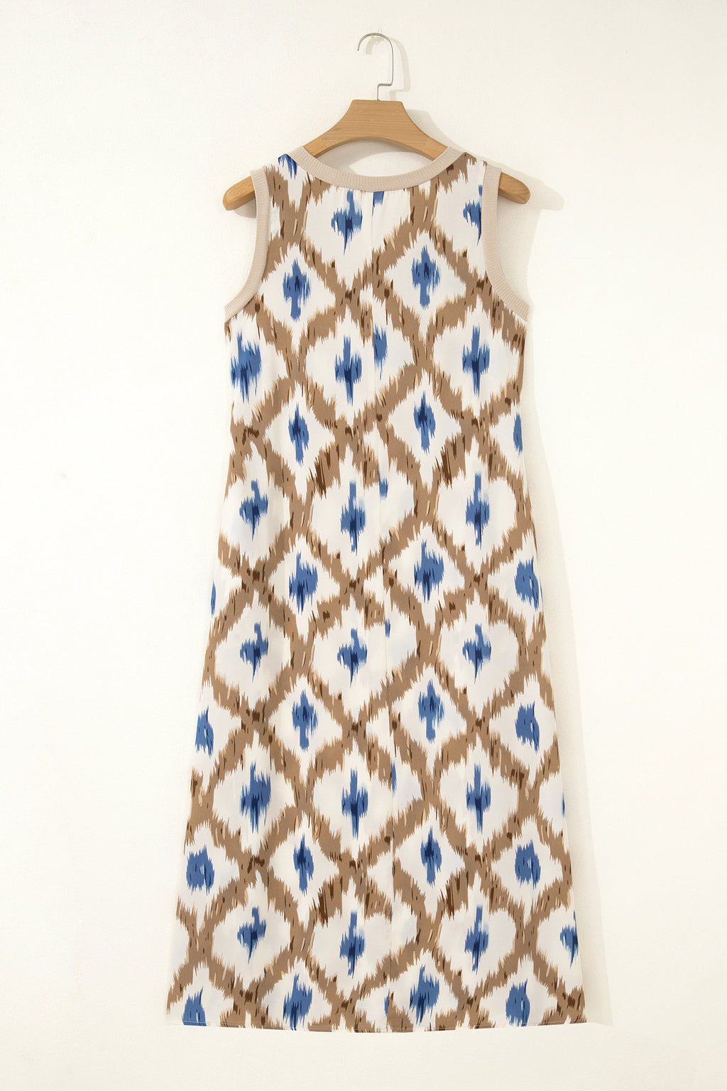 Dress with blue and brown pattern on a hanger against a white background back view