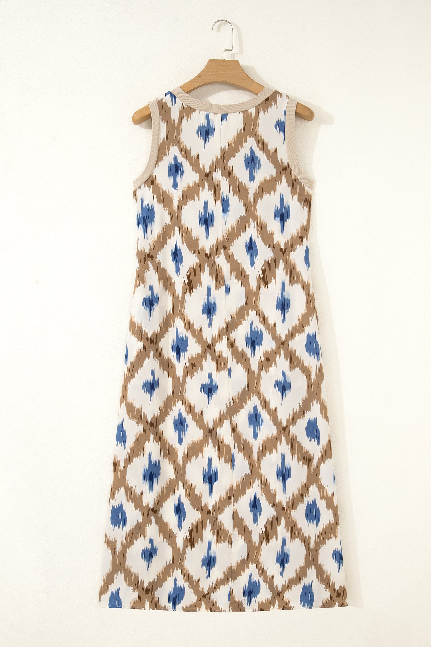 Dress with blue and brown pattern on a hanger against a white background back view