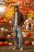 Male model wearing a pair of Men's Washed Straight Leg Jeans at a fall festival 