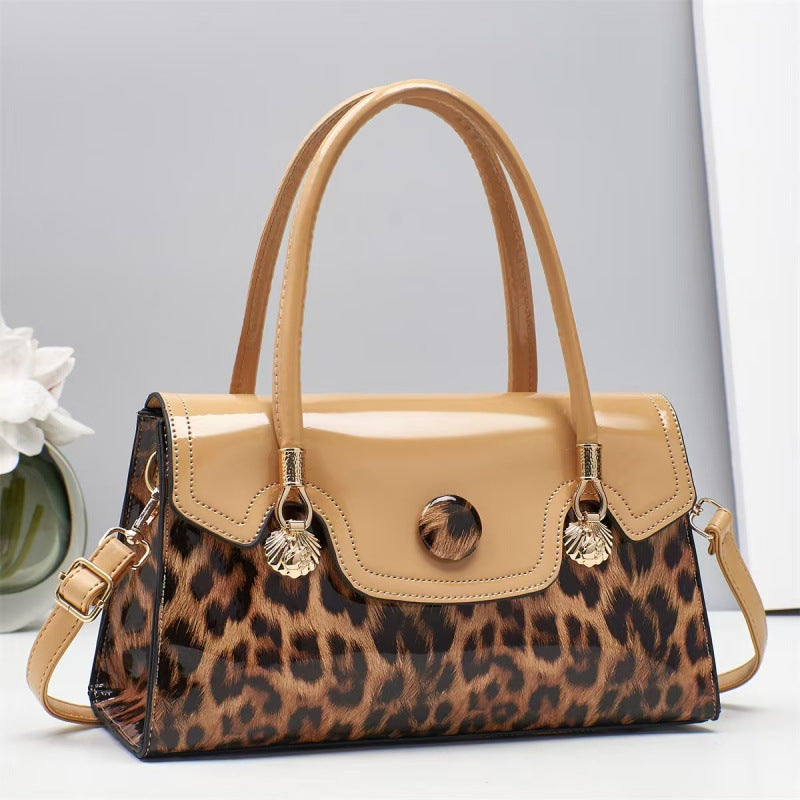 Leopard print handbag with beige top section on a light gray background