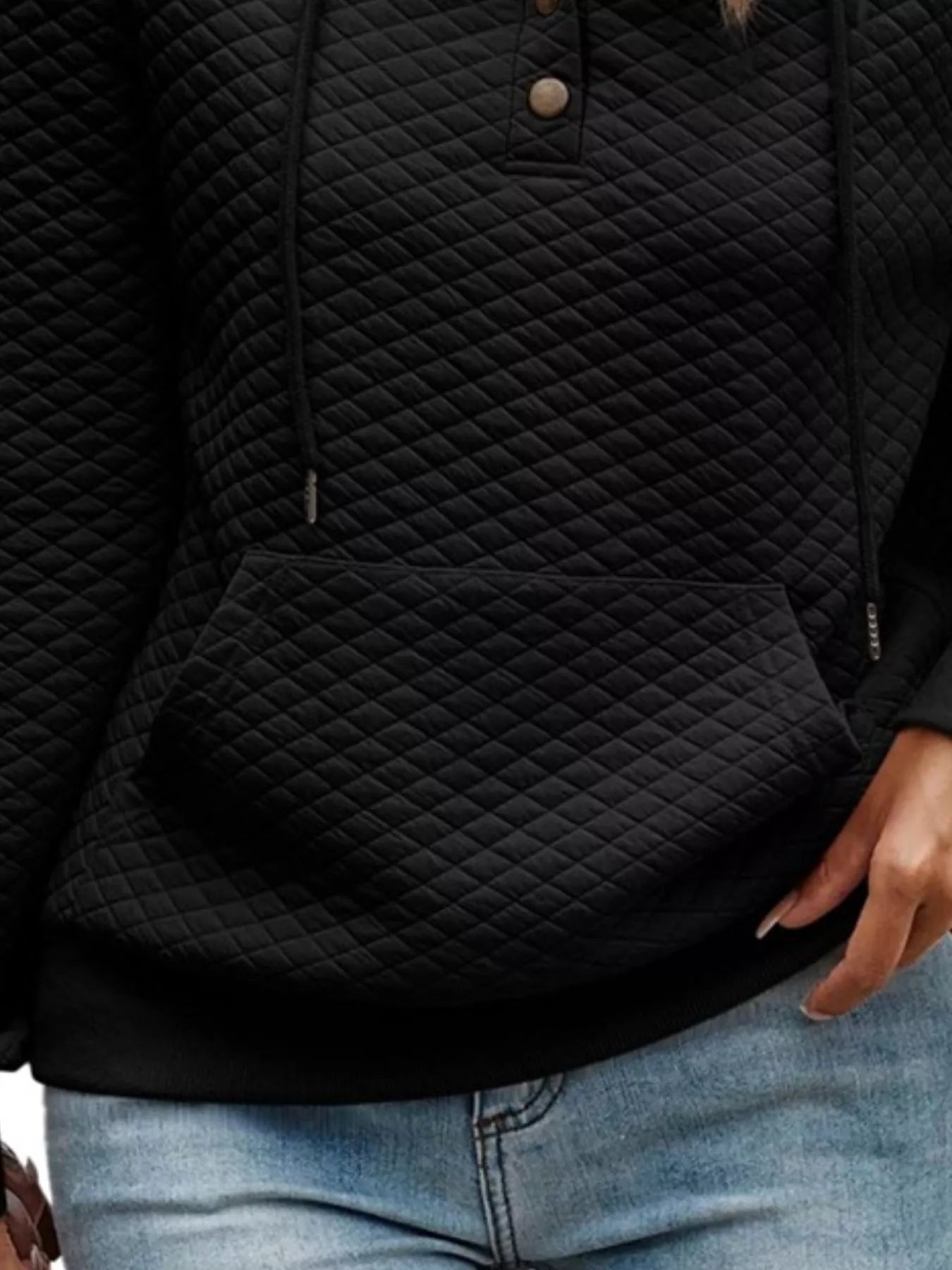 Black quilted jacket worn by a person with jeans