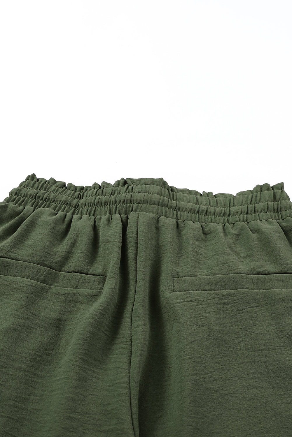 Close-up of green pants with an elastic waistband on a white background
