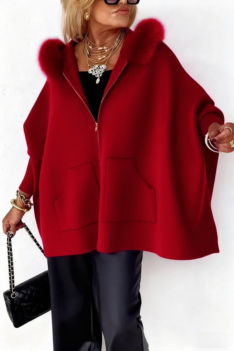 Person wearing a red coat with fur hood on a white background