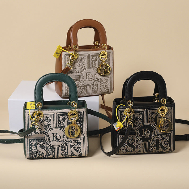Three small handbags with decorative patterns and gold keychains on a beige background