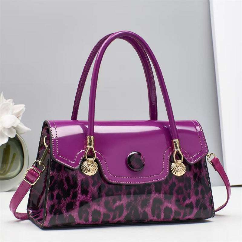 Purple handbag with leopard print and gold accents on a light gray background