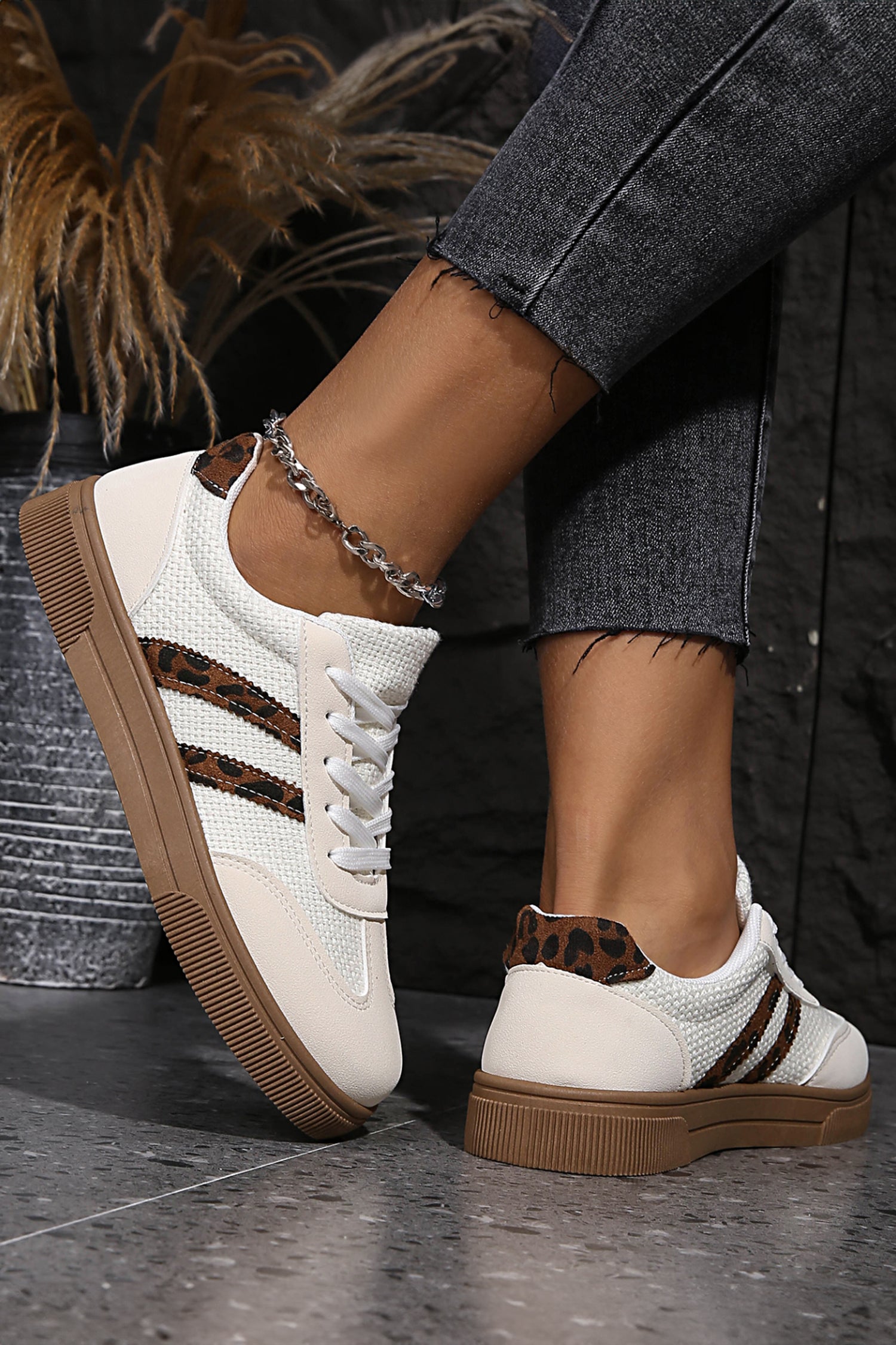White sneakers with brown soles and leopard print accents 