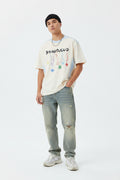 Male model wearing an apricot "Bangouluo" Graphic Short Sleeve T-Shirt