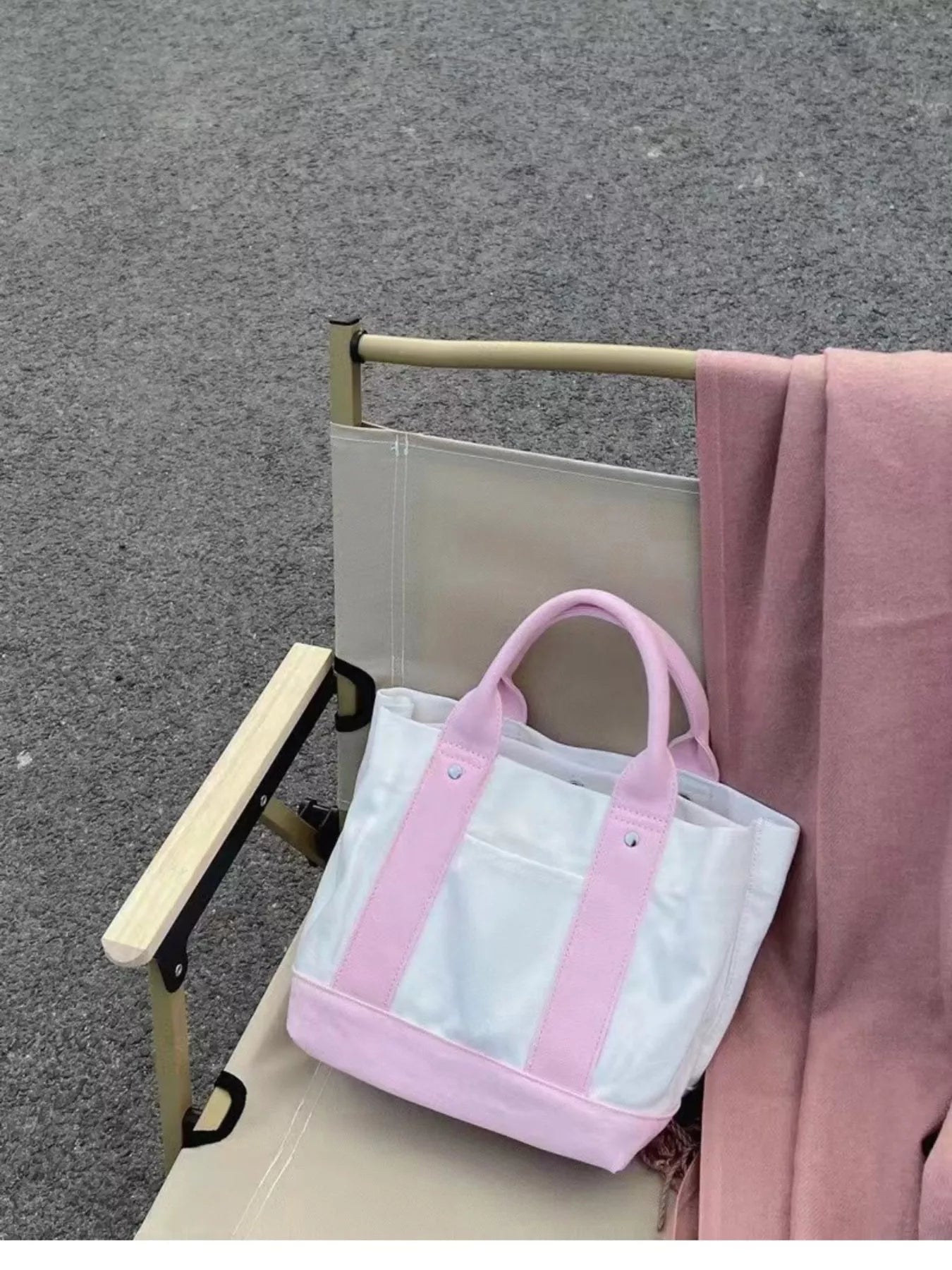 Pink tote bag with clear front pocket on a chair outdoors