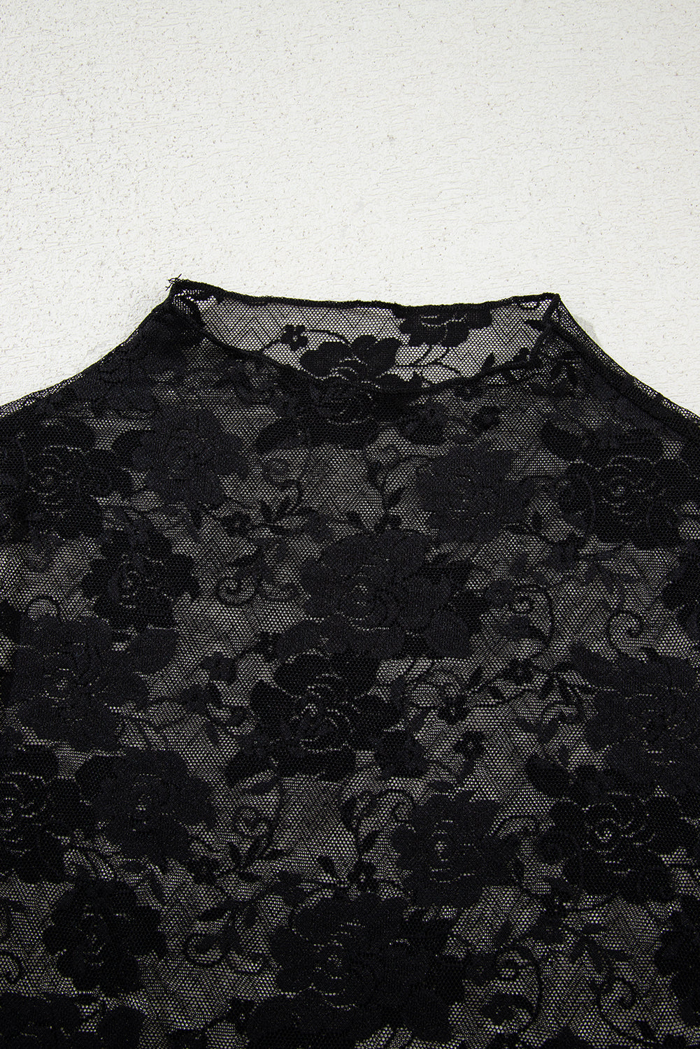 Black floral lace fabric on a white background