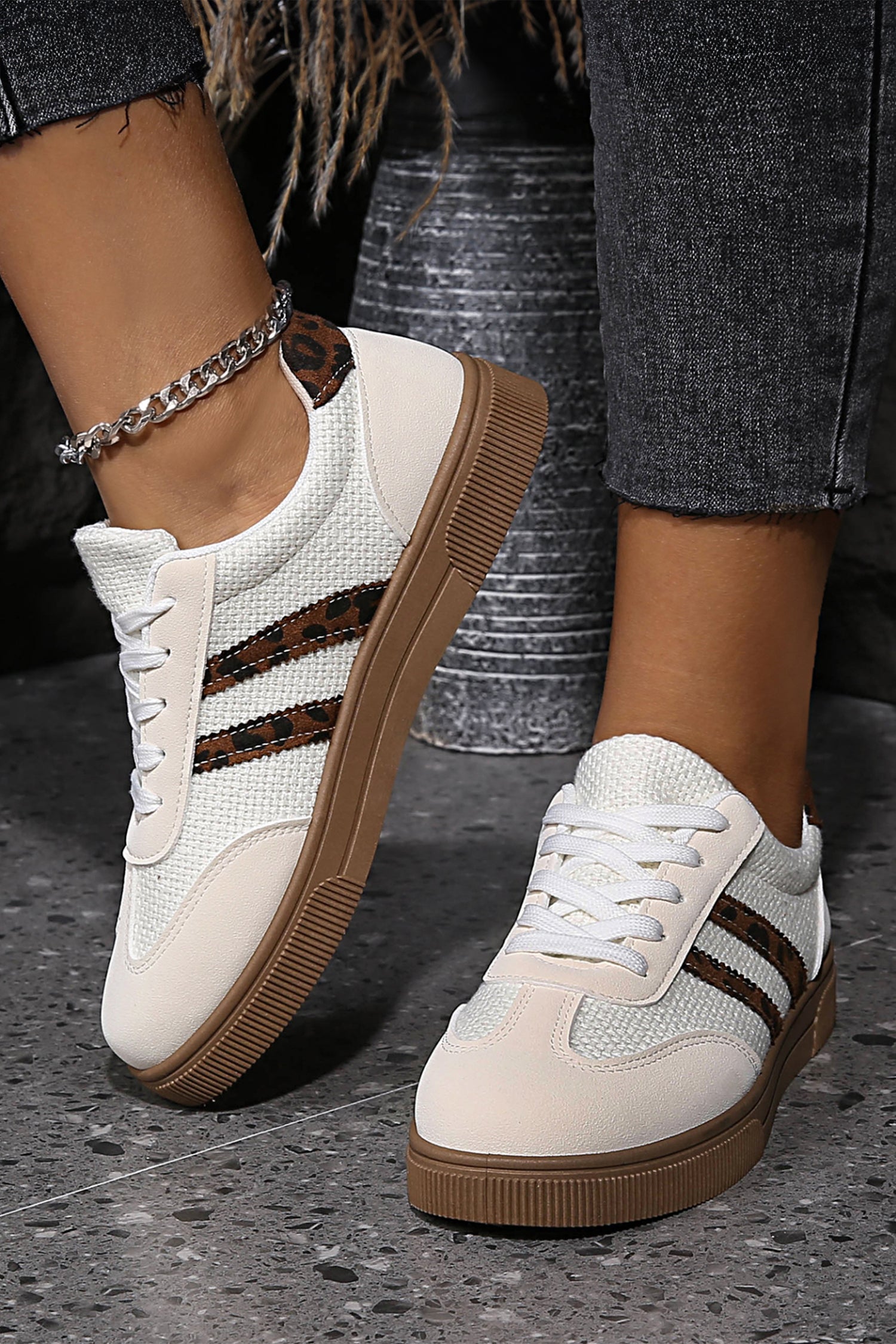 White sneakers with brown leopard stripes worn side view